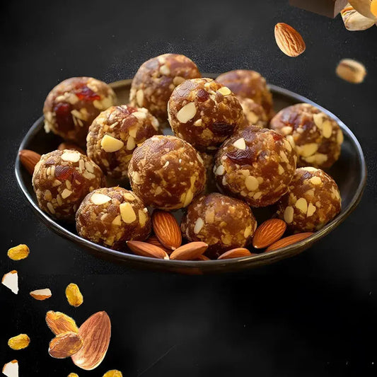 Premium homemade dry fruit laddoo with cashew, almond, pistachio, and saffron, served on a marble slab.